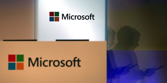A shadow of a man using his mobile phone is cast near Microsoft logo at the 2014 Computex exhibition in Taipei June 4, 2014. Computex, the world's second largest computer show, runs from June 3 to 7. REUTERS/Pichi Chuang (TAIWAN - Tags: BUSINESS LOGO SCIENCE TECHNOLOGY) - RTR3S3OQ