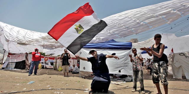 An Egyptian man dances with a national flag as he protests for a second day in Tahrir Square in Cairo, Egypt. What appeared an unstoppable groundswell for change across the Middle East earlier this year, has splintered into scattered and indecisive conflicts that have left thousands dead and Western policy makers juggling roles ranging from NATO airstrikes in Libya to worried bystanders in Syria and Yemen.
