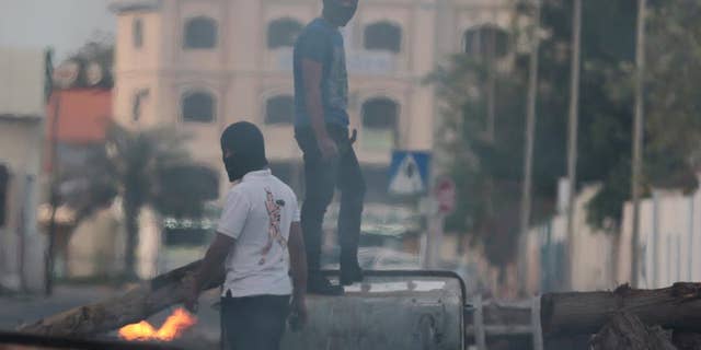 Bahraini anti-government protesters close roads with debris to slow riot police at the start of clashes in Shakoura, Bahrain, Friday, April 4, 2014. Clashes erupted after tens of thousands of the protesters carrying signs and images of jailed political leaders marched in Saar, Bahrain. Protesters also raised signs against the Formula One Bahrain Grand Prix, which is being held Sunday in the Gulf island kingdom. (AP Photo/Hasan Jamali)