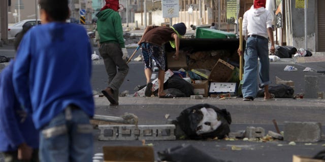 March 16: Shiite Bahraini youths haul debris into the streets to build barricades in the western village of Malkiya, Bahrain, in preparation for government-supporting forces which they expect will role into their Shiite Muslim village southwest of the capital of Manama.