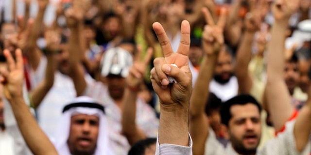 April 21, 2012: Bahraini anti-government protesters gesture as they march in Diraz, Bahrain, west of the capital of Manama.