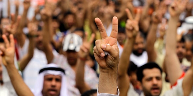 April 21, 2012: Bahraini anti-government protesters gesture as they march in Diraz, Bahrain, west of the capital of Manama.