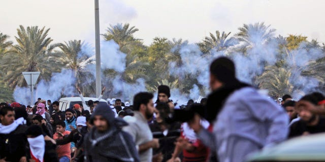 DEc. 23, 2011: Anti-government protesters run as riot police begin firing tear gas.