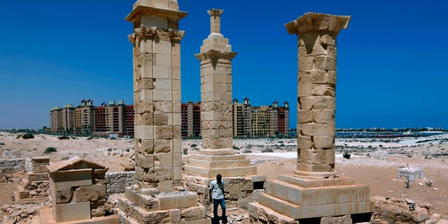 With a five star hotel in the background, a man walks by restored Roman pillar tombs of the ancient city of Leukaspis a well known Greco-Roman port overlooking the Mediterranean Sea at the costal resorts of Marina, Egypt Sunday, Aug. 29, 2010. Today, it's a sprawl of luxury vacation homes where Egypt's wealthy play on the white beaches of the Mediterranean coast. But 2,000 years ago, this was a thriving Greco-Roman port city, boasting villas of merchants grown rich on the wheat and olive trade.