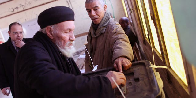 January 15, 2014: Father Antonious casts his ballot in a constitutional referendum inside a polling station in Dalga village of Minya, Egypt. Father Antonious is one of the priests of the Virgin Mary and St. Abraam Monastery that was looted and burned by supporters of ousted Islamist President Mohammed Morsi in August. Christians are voting "yes" on a new charter that criminalizes discrimination and instructs the next legislature to ease restrictions on building churches. (AP Photo/Roger Anis, El Shorouk Newspaper)