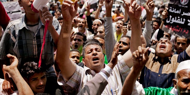 Egyptians gather to protest military rule in Tahrir Square in Cairo, Egypt on Friday, June 15, 2012. Judges appointed by Hosni Mubarak dissolved the Islamist-dominated parliament Thursday and ruled his former prime minister eligible for the presidential runoff election this weekend, setting the stage for the military and remnants of the old regime to stay in power. (AP Photo/Pete Muller)