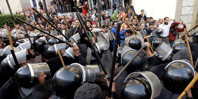 Jan. 26, 2011: Egyptian anti-riot police confront Egyptian activist outside a journalists syndicate in downtown Cairo, Egypt. A small gathering of Egyptian anti-government activists tried to stage a second day of protests in Cairo Wednesday in defiance of a ban on any gatherings, but police quickly moved in and used force to disperse the group.