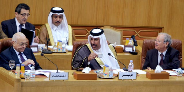 Nov. 12, 2011: Qatari Foreign Minister Hamad bin Jasim, center, looks at Arab League secretary-general Nabil al-Arabi Nabil, left, during an Arab League emergency session on Syria at the Arab League headquarters in Cairo, Egypt.