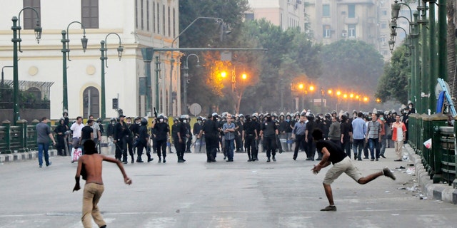 Sept. 15, 2012: Egyptian protesters hurl stones at riot police in downtown Cairo, Egypt, before police cleared the area after days of protests against a film ridiculing the Prophet Muhammad.