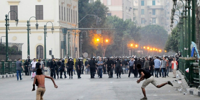 Sept. 15, 2012: Egyptian protesters hurl stones at riot police in downtown Cairo, Egypt, before police cleared the area after days of protests against a film ridiculing the Prophet Muhammad.