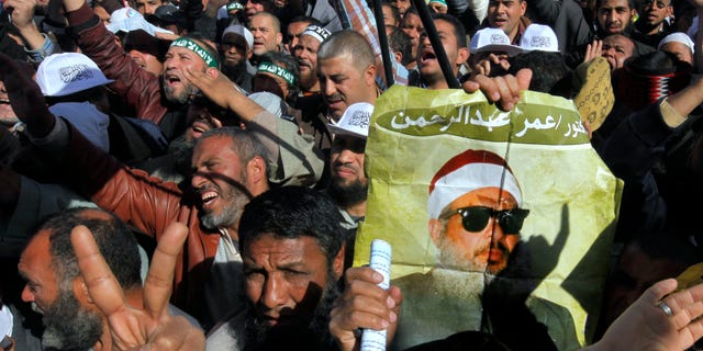 Feb. 15, 2013: Supporters of Sheik Omar Abdel-Rahman, a blind Egyptian cleric jailed in the United States for planning a campaign of bombings, call for his release while one demonstrator holding a poster with his image, during a rally outside Cairo University in Cairo, Egypt.