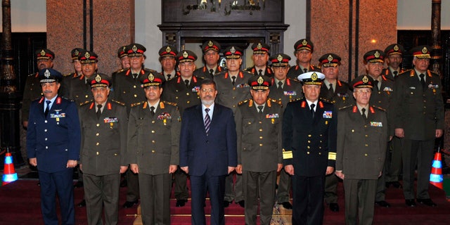 April 11, 2013: In this image released by the Egyptian Presidency, Egyptian President Mohammed Morsi, center, poses with military officers after a meeting with the Supreme Council of the Armed Forces in Cairo, Egypt.