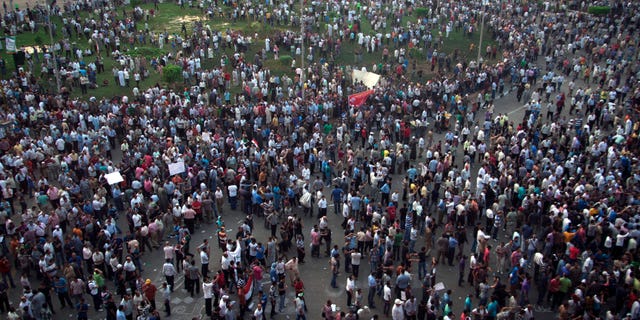 Protesters gather in Tahrir square in Cairo, Egypt, Friday, Oct. 12, 2012. Thousands of supporters and opponents of Egypt's new Islamist president clashed in Cairo's Tahrir Square on Friday, hurling stones and concrete and swinging sticks at each other in the first such violence since Mohammed Morsi took office more than three months ago.(AP Photo/Khalil Hamra)
