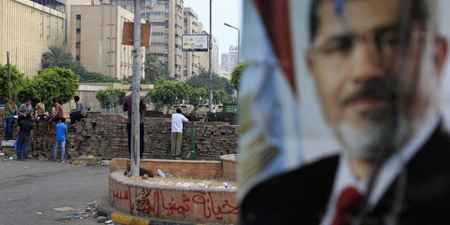 July 10, 2013: Supporters of ousted President Mohammed Morsi protest as army soldiers guard at the Republican Guard building in Nasr City, in Cairo, Egypt.