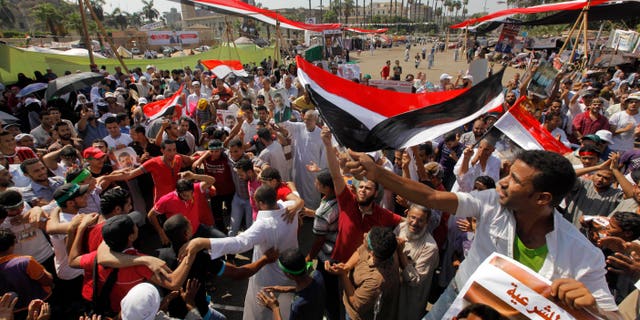 Aug.2, 2013 - Supporters of Egypt's ousted President Mohammed Morsi shout slogans at a rally near Cairo University in Giza, Egypt. Arabic reads, "to legitimacy."