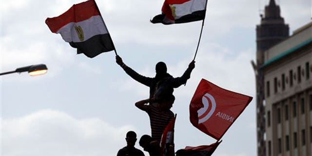 April 8: Egyptians wave Egyptian and Tunisian flags as they attend a rally in Tahrir square in Cairo, Egypt. Protesters held a mock trial of Hosni Mubarak, his family and his top aides in Cairo's central Tahrir Square where tens of thousands of Egyptians massed demanding the ruling military prosecute them for alleged corruption in one of the country's largest rallies since the longtime president was ousted two months ago. (AP)