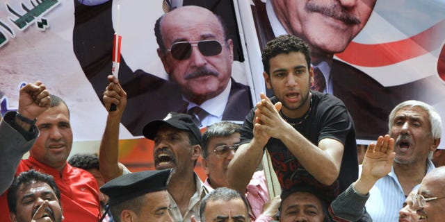 April 8, 2012: Supporters of former Egyptian Vice President Omar Suleiman chant in front of his posters out side the Higher Presidential Elections Commission, in Cairo, Egypt.