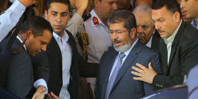 June 29, 2012: Egypt's President-elect Mohammed Morsi is guarded by presidential security as he leaves Friday prayers at Al-Azhar mosque, in Cairo, Egypt.
