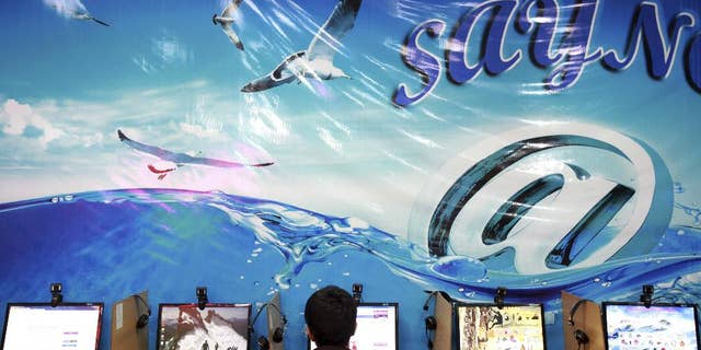 FILE - In this Tuesday, Sept, 17, 2013 file photo, an Iranian man surfs the Internet at a cafe in Tehran, Iran. Iran's official news agency reported on Sunday, July 13, 2014 that eight Facebook page administrators have been handed jail sentences from eight to 21 years. The report by IRNA says the defendants were convicted of plotting against national security, spreading propaganda against the ruling system and insulting officials. It did not identify the defendants or the Facebook pages. (AP Photo/Ebrahim Noroozi, File)