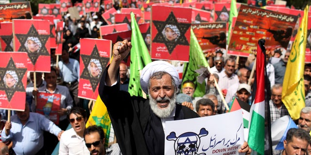 Aug. 2, 2013 - An Iranian cleric holding an anti-Israeli placard chants slogan, while attending an annual pro-Palestinian rally marking Al-Quds (Jerusalem) Day in Tehran, Iran. Thousands of Iranians marched in support of Muslim claims to the holy city of Jerusalem.