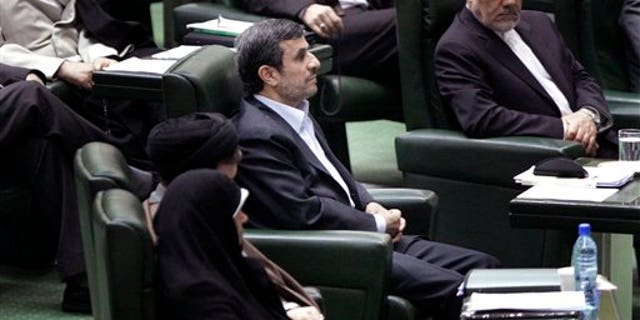 March 14: Iranian President Mahmoud Ahmadinejad, center, listens to conservative lawmaker Ali Motahari, unseen, a prominent opponent of the president, as he reads out a series of questions to Ahmadinejad in an open session in parliament in Tehran, Iran.
