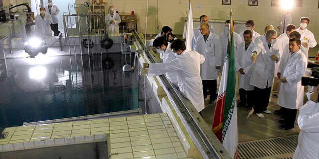 FILE- In this Feb. 15, 2012, file photo, provided by the Iranian President's Office, Iranian President Mahmoud Ahmadinejad, right, is escorted by technicians during a tour of Tehran's research reactor center in northern Tehran, Iran. Iran's envoys are heading for nuclear talks with confidence that the chips are falling their way. Iran's denials that it is trying to develop nuclear weapons carry a distinctly hollow ring among its foes as the U.N. nuclear watchdog piles on worries: Complaining about limits on inspection access and reporting that Tehran is expanding its nuclear fuel labs. But, as Israel increasingly weighs the option of a military strike, Western leaders wary of another Middle East conflict may have to pay closer attention to the claims. (AP Photo/Iranian President's Office, File)