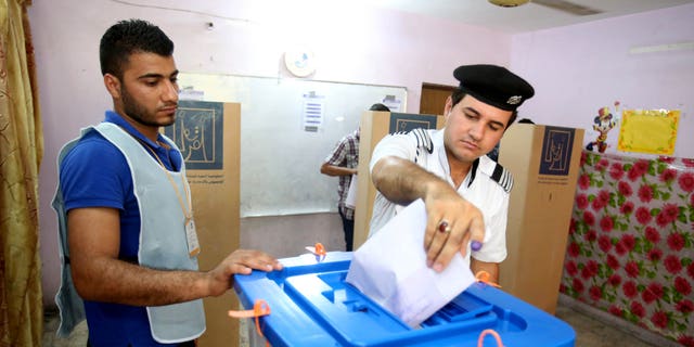 April 28, 2014 - An Iraqi traffic policeman casts his vote at a polling center in Baghdad, Iraq. Iraqi officials say suicide bombers have targeted polling centers as soldiers and security forces cast ballots ahead of parliamentary elections.