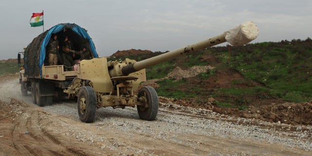 Dec. 19, 2014: Iraqi Kurdish forces tow a howitzer near the front lines on their way to the city of Sinjar, as the Kurdish peshmerga fighters move through Zumar, Iraq. (AP Photo/Zana Ahmed)