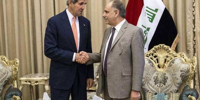 Iraqi Deputy Prime Minister Saleh al-Mutlaq, right, greets U.S. Secretary of State John Kerry before a meeting in the capital Baghdad, Iraq, Monday, June 23, 2014. Kerry said the fate of Iraq may be decided over the next week and is largely dependent on whether its leaders meet a deadline for starting to build a new government. (AP Photo/Brendan Smialowski, Pool)