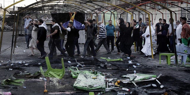 FILE - In this Sept. 22, 2013 file photo, mourners carry the coffin of a man killed on Saturday from a double suicide bomb attack in the Shiite neighborhood of Sadr city in Baghdad, Iraq. (AP Photo)