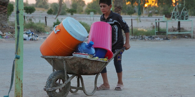 In this Aug. 4, 2014, photo, an Iraqi boy in a camp of displaced Iraqis who fled from their towns after advances by Islamic militants take shelter in Najaf, Iraq.