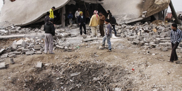Dec. 17, 2012 - People inspect scene of a car bomb attack in al-Mouafaqiyah, a village inhabited by families from the Shabak ethnic group, near the city of Mosul, northwest of Baghdad.