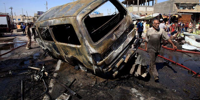 July 29, 2013: People and security forces inspect the site of a car bomb explosion in Basra, 340 miles southeast of Baghdad, Iraq.
