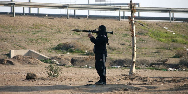 January 12, 2014: A gunman holds his weapon as he stands guard in Fallujah, 40 miles west of Baghdad, Iraq. Iraqi forces have yet to militarily try to reassert control over Fallujah, which remains in the hands of the militants and tribal gunmen opposed to the central government. (AP Photo)