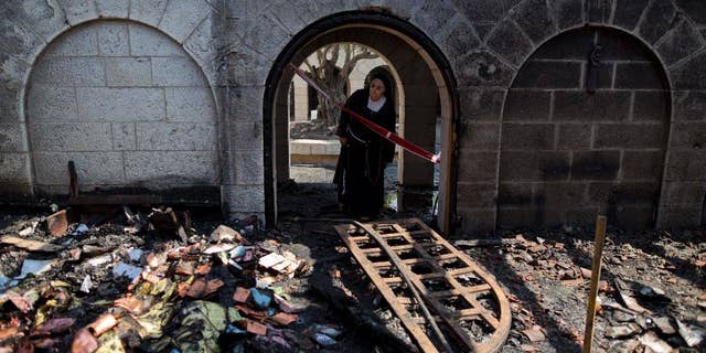 A nun looks at damage to the Church of the Multiplication of the Loaves and Fish in June 2015.