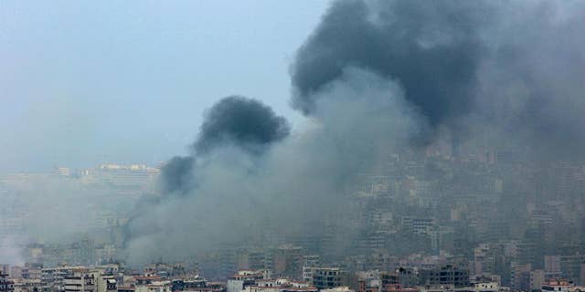 FILE - In this Sunday July 16, 2006 file photo, black smoke rises from the demolished headquarters of Hezbollah in the suburbs of Beirut, Lebanon, following Israeli air strikes. Hezbollah is building up a massive arsenal of rockets and other advanced weaponry in an arms race that may lead to a new war between Israeli and the militant Lebanese group, a senior Israeli military intelligence official said Wednesday, May 13, 2015. (AP Photo/Kevork Djansezian, File)
