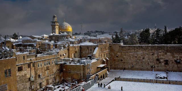 File - In this Dec. 13, 2013 file photo, the Western Wall, right, and the gilded Dome of the Rock, among the holiest sites for Jews and Muslims, are covered in snow. The trapezoid-shaped compound, known to Muslims as the Noble Sanctuary and to Jews as the Temple Mount, is at the heart of the territorial and religious conflict between Israel and its Arab neighbors. It has been the site of recent unrest. (AP Photo/Dusan Vranic, File)