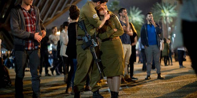 Israeli soldiers and other Israelis attend a ceremony marking Israel's annual Memorial Day for fallen soldiers, in Tel Aviv, Israel, Tuesday, April 21, 2015. (AP Photo/Oded Balilty)