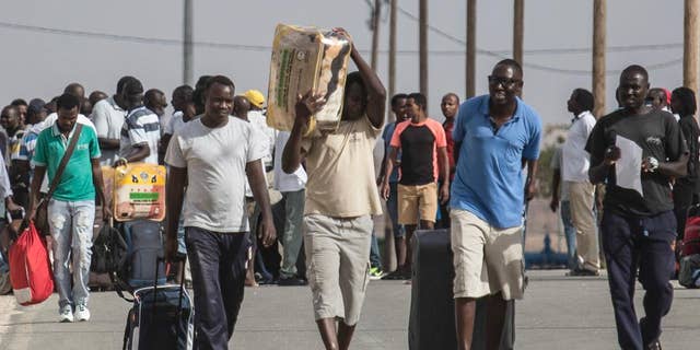 African illegal migrants walk out of the Holot detention center in the Negev desert in southern Israel, Tuesday, Aug. 25, 2015. Since it passed a 2012 “anti-infiltration” law, Israel has sent 1,700 migrants to the Holot facility deep in Israel’s Negev desert. Israel's Supreme Court upheld the law in the latest hearing but ruled that migrants held at Holot for more than 12 months must be freed. About 1,200 migrants are being released beginning Tuesday. (AP Photo/Tsafrir Abayov)