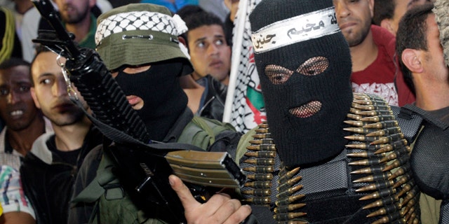April 7, 2014: A Palestinian militant holds a weapon during a ceremony to mark the 12th anniversary of the Israeli army's 'Defensive Shield' operation in the West Bank refugee camp of Jenin. (AP Photo/Mohammed Ballas)