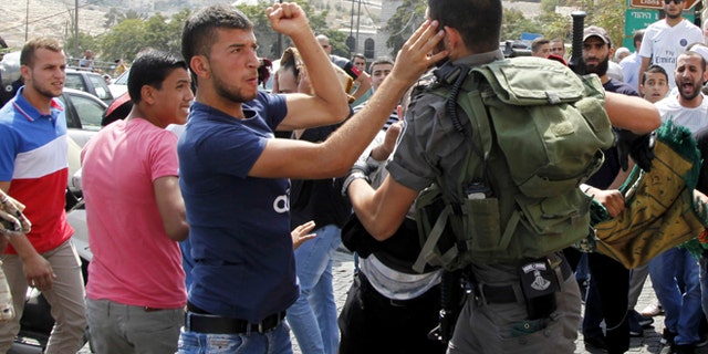 Oct. 2, 2015: An Israeli border policeman exchanges blows with a Palestinian man during a confrontation after Friday prayers outside the Old City in Jerusalem.