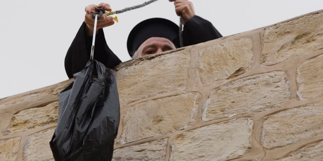 Jan. 6: Former Greek Patriarch Irineos I pulls up a bag of groceries to his apartment in the Old City of Jerusalem.