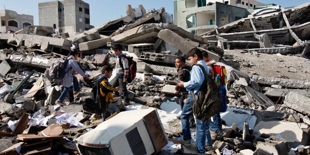 Nov. 26, 2012 - Palestinian school children walk in the rubble left days after an Israeli strike destroyed the Hamas interior ministry in Gaza City.