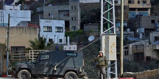 March 12: Israeli troops operate in the West Bank village of Awarta, after five people were killed in the nearby Jewish settlement of Itamar. A Palestinian infiltrated Itamar early Saturday and killed five people, the Israeli military said. Israeli media is reporting that the dead are all members of the same family with parents and three children aged 11, 3 and an infant, all reported to have been stabbed while they slept. (AP)