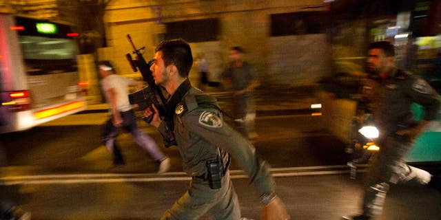 FILE - In a Wednesday, Oct. 14, 2015 file photo, Israeli policemen run looking for a possible stabbing suspect in Jerusalem. A sudden wave of stabbing attacks has spread fear in Jerusalem and much of Israel. (AP Photo/Dusan Vranic, File)
