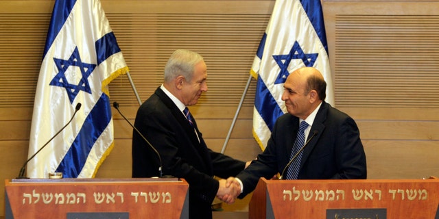 May 8, 2012: Israel's Prime Minister Benjamin Netanyahu, left, and Kadima party leader Shaul Mofaz shake hands before holding a joint press conference announcing the new coalition government, in Jerusalem.