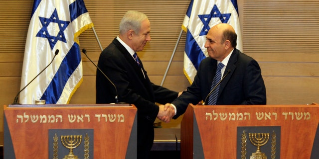May 8, 2012: Israel's Prime Minister Benjamin Netanyahu, left, and Kadima party leader Shaul Mofaz shake hands before holding a joint press conference announcing the new coalition government, in Jerusalem.