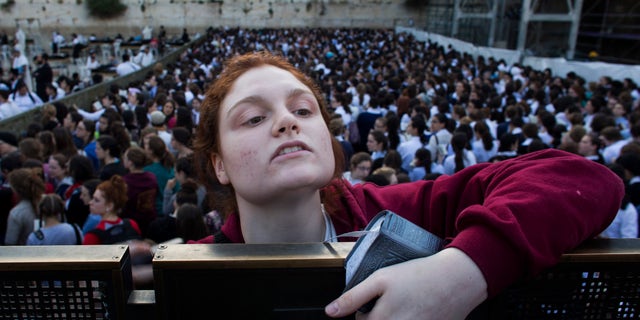 A Jewish orthodox woman follows a prayer organized by the "Women of the Wall" organization.