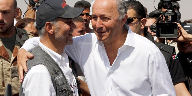 French Foreign Minister Laurent Fabius, right, greets an official from the Jordan Hashemite Charity Organization during his visit to the Zaatari Syrian refugee camp in Mafraq, Jordan, Thursday, Aug. 16, 2012. Fabius is on a three-day visit to countries neighboring Syria. (AP Photo/Raad Adayleh)