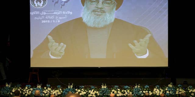 Hezbollah leader Sheikh Hassan Nasrallah speaks via video to his supporters in the southern suburb of Beirut, Lebanon, Friday Jan. 9, 2015. The leader of the Lebanese Hezbollah group said Islamic extremists have insulted the prophet of Islam with their terror more than those who published drawings mocking him. (AP Photo/Hussein Malla)